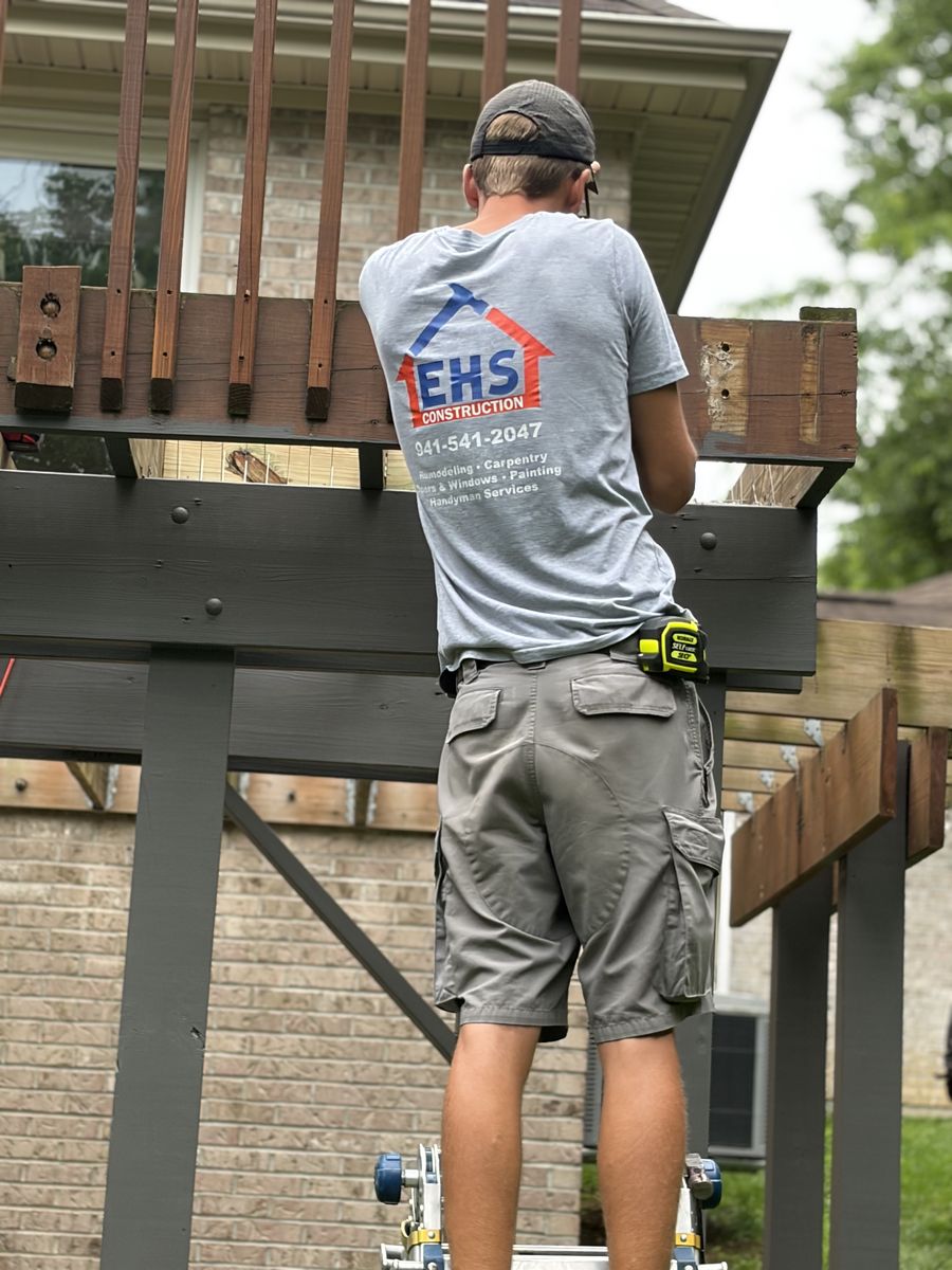 EHS Construction craftsman installing a custom deck railing