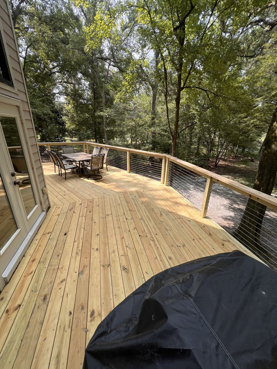 Completed wood deck renovation with cable railing